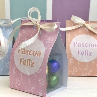 Caixa de presente com ovinhos de chocolate coloridos e etiqueta 'Páscoa Feliz'