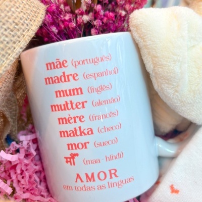 Caneca branca com texto em várias línguas destacando a palavra 'mãe' e 'AMOR em todas as línguas'