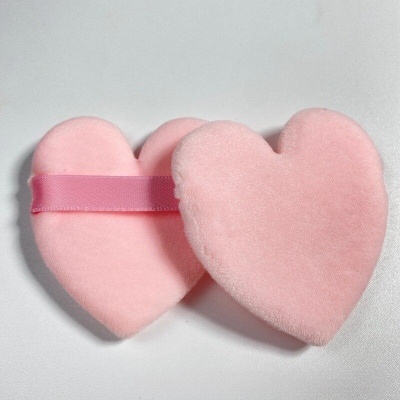 Dois corações cor-de-rosa de pelúcia, um com fita de cetim rosa, sobre fundo branco