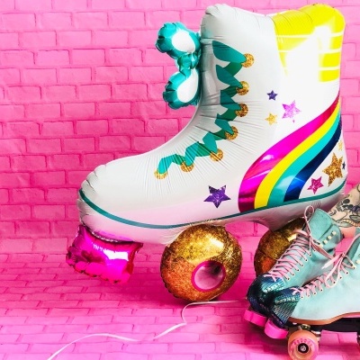 Patins de rodas coloridos com parede e chão rosa