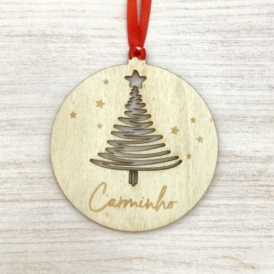 Enfeite natalício circular em madeira com desenho de árvore de Natal e texto Caminho