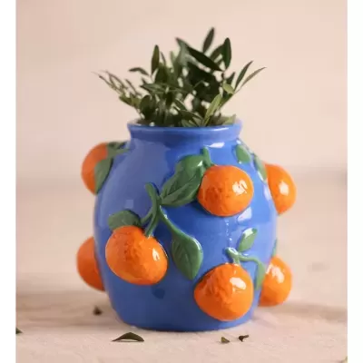 Vaso cerâmico azul com tangerinas em relevo e planta verde