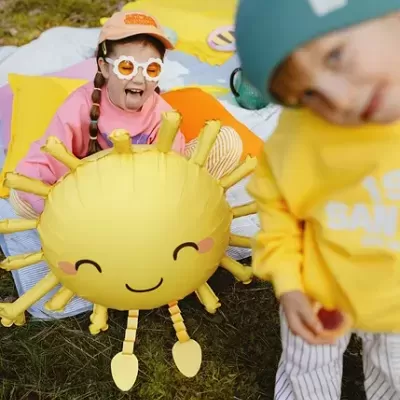 Crianças com roupas coloridas e almofada inflável amarela sorridente ao ar livre
