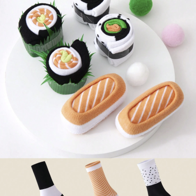 Meias dobradas decorativamente, imitando sushi e nigiri, com padrões listrados e pontilhados, ao lado de bolas de feltro coloridas.
