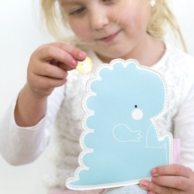 Criança a colocar uma moeda num mealheiro dinossauro azul