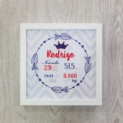 Quadro emoldurado branco com dados de nascimento em azul e vermelho, fundo cinza ziguezague