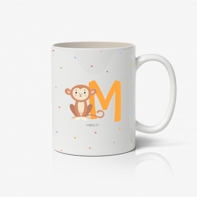 Caneca branca com desenho de macaco, letra M laranja e bolinhas coloridas