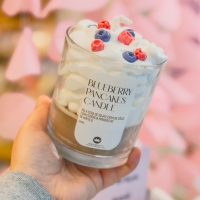 Vela decorativa em frasco de vidro com cera branca e decoração de frutas artificiais