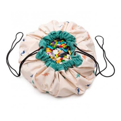 Saco de brinquedos redondo em tecido com estampado de dinossauros e peças de montar coloridas dentro