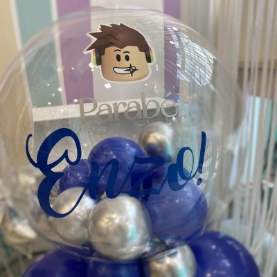 Balão transparente decorado com adesivo e texto azul com balões azuis e prateados dentro