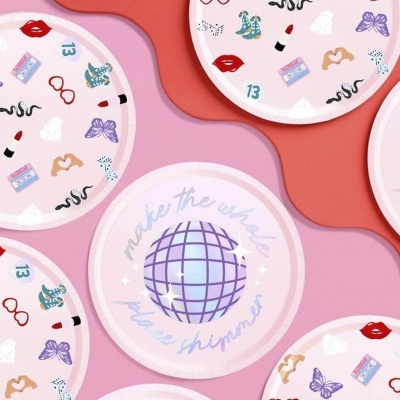 Tampas de plástico cor-de-rosa com desenhos coloridos e texto 'make the whole planet shimmer'