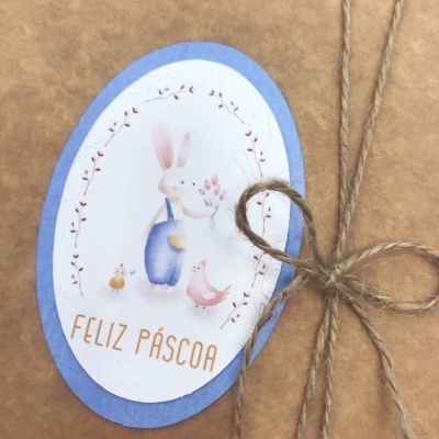 Etiqueta de Páscoa com coelho e texto 'FELIZ PÁSCOA' numa embalagem de papel castanho