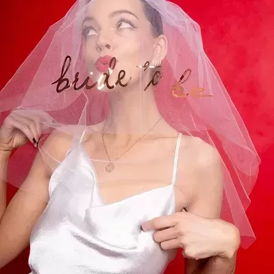 Véu de noiva branco com texto dourado bride to be sobre vestido branco