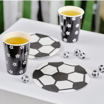 Copos e pratos com tema de futebol e mini bolas de futebol numa mesa branca