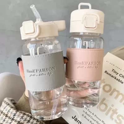 Duas garrafas de água transparentes com capa cinza e rosa, tampas brancas e bico retrátil