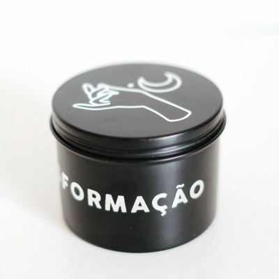 Frasco preto com tampa decorada com mão e lua brancas, texto FORMÇÃO na lateral.