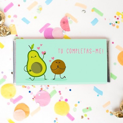 Barra de chocolate com embalagem azul clara, ilustração de abacate e noz com texto 'TU COMPLETAS-ME!'