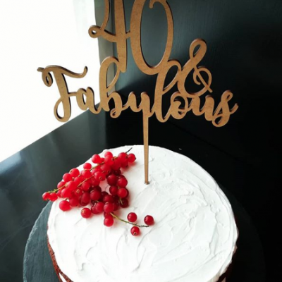 bolo branco com placa de madeira '40 & Fabulous' e bagas vermelhas