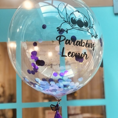 Balão transparente com confettis e texto Parabéns Leonor com personagem Stitch