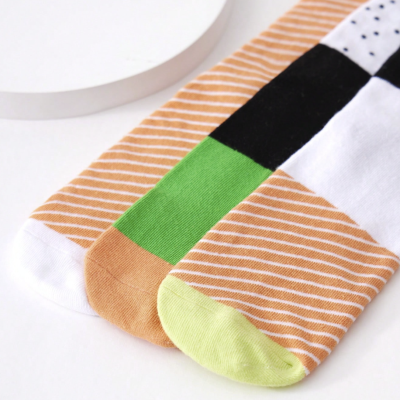 Três meias coloridas com padrão de riscas e detalhes coloridos nos dedos