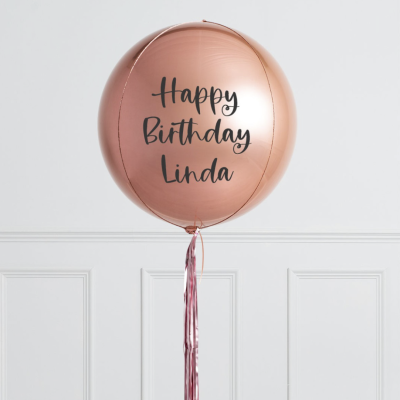Balão metálico rosa com texto de aniversário e fita pendente