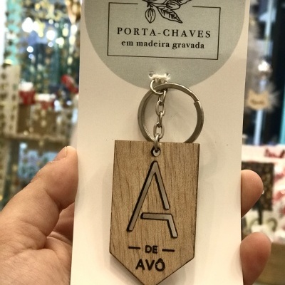 Porta-chaves em madeira gravada com texto 'A DE AVÔ' em embalagem branca