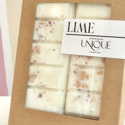 Bloco de cera branca com ervas secas em caixa de cartão com etiqueta