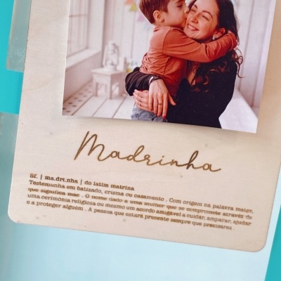 Foto de criança abraçando mulher com texto sobre madrinha em folha