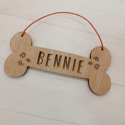 Placa de madeira em forma de osso com o nome BENNIE gravado