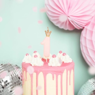 Bolo de aniversário rosa e branco com vela 1 e decoração festiva