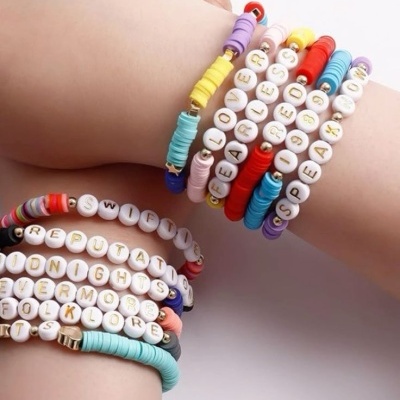 Pulseiras coloridas com contas de letras em pulsos