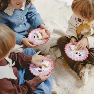 Crianças sentadas segurando pratos de papel com bolachas em forma de ossos