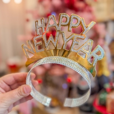 Tiara dourada com letras glitter dizendo HAPPY NEW YEAR e base prateada brilhante
