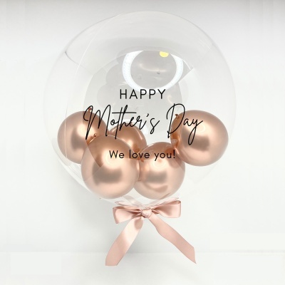 Balão transparente decorado com balões cor de rosa e texto 'Happy Mother's Day We love you!'