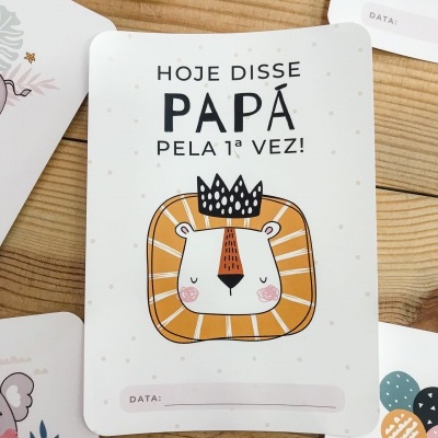 Cartão de recordação com ilustração de leão e texto em português sobre mesa de madeira