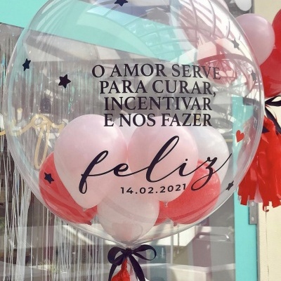 Balão transparente decorado com pequenos balões coloridos e texto sobre amor