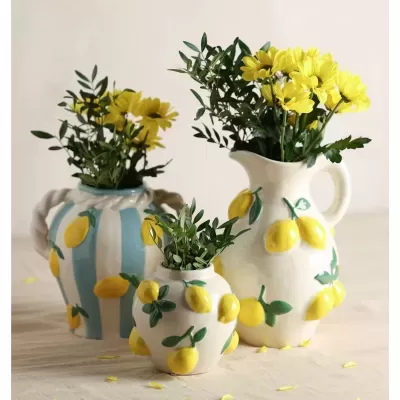 Três jarros decorativos com limões pintados e flores amarelas