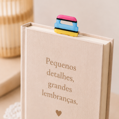 Livro bege com texto dourado e marcador colorido em cima