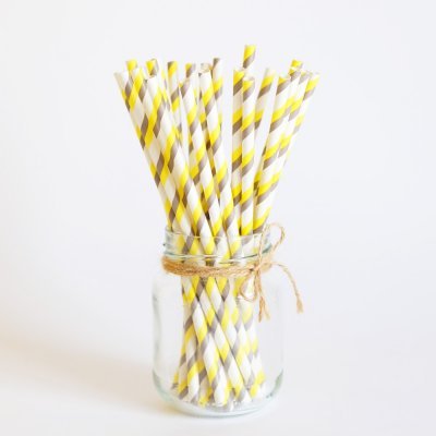 Frasco de vidro com canudos de papel amarelos e cinzentos