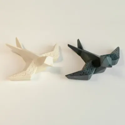Esculturas decorativas de pássaros creme e cinza com padrão de escamas