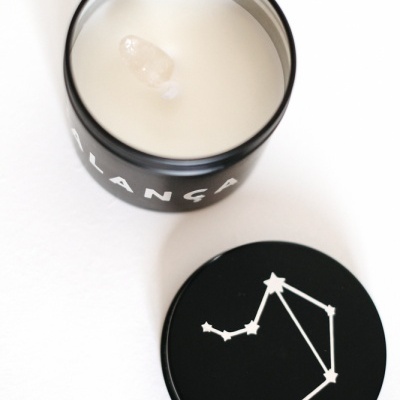 Vela branca numa embalagem negra com tampa com constelação branca