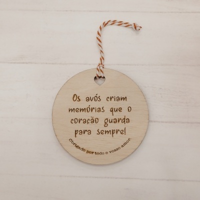 Ornamento redondo de madeira clara com texto gravado e cordão vermelho e branco para pendurar
