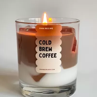 Vela em copo de vidro com cera castanha e branca e etiqueta ONNI RECIPE COLD BREW COFFEE.