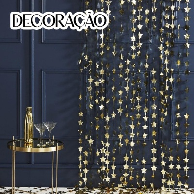 Cortina decorativa dourada com estrelas e mesa metálica com copos