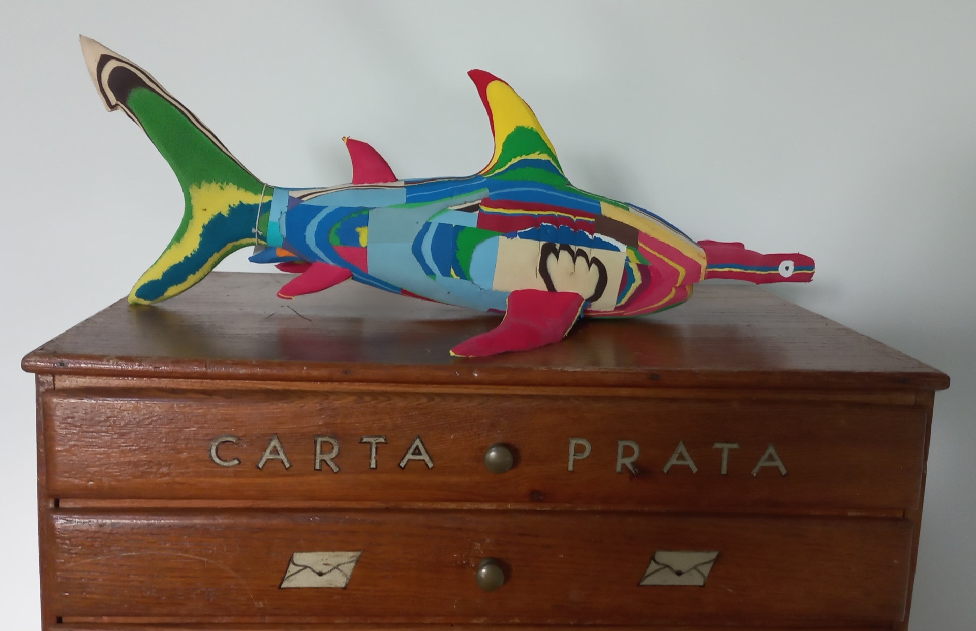 Tubarão Martelo M Peixe decorativo colorido em cima de cómoda de madeira