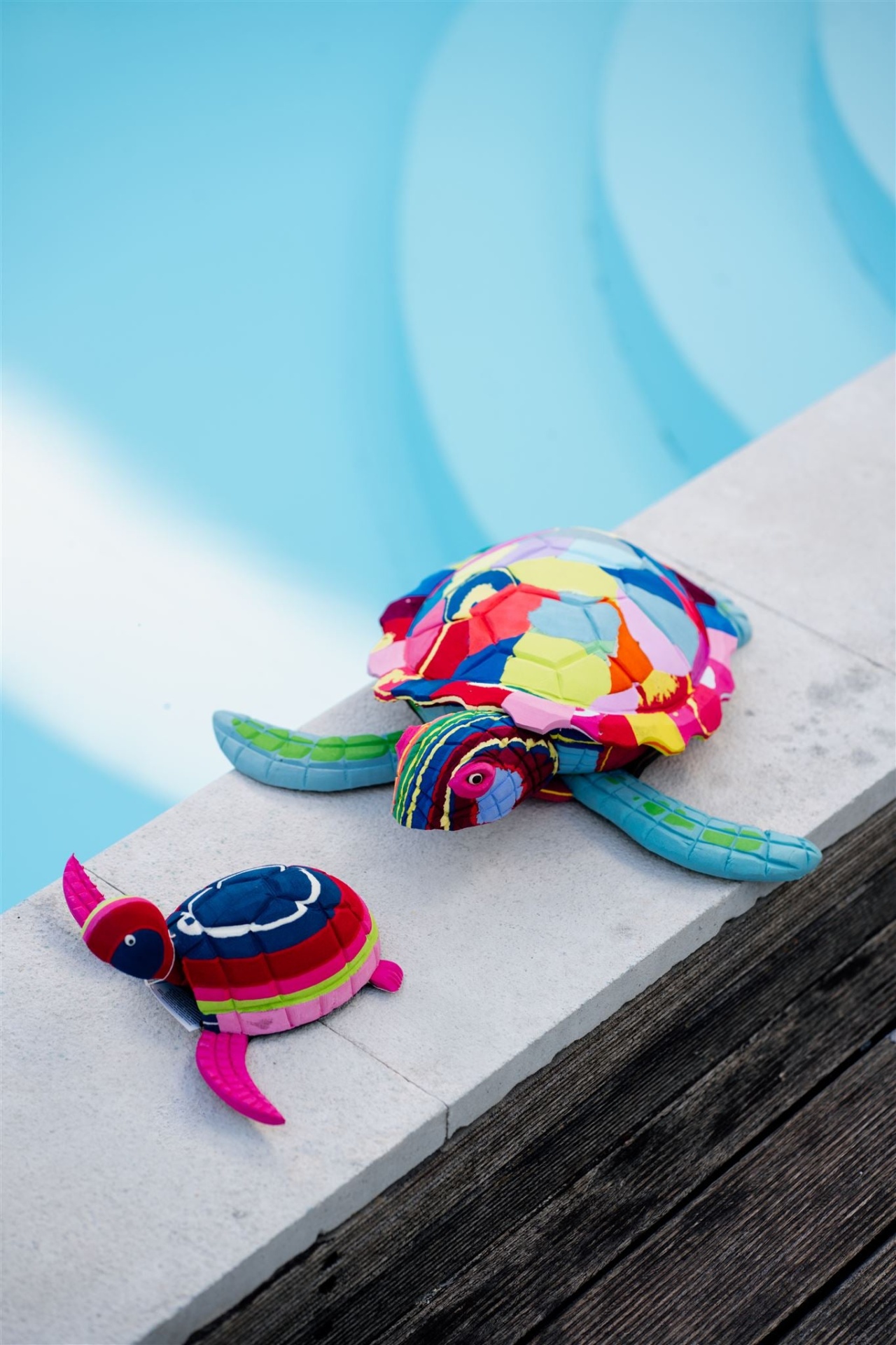 Tartaruga L Duas tartarugas de peluche coloridas em patchwork junto a uma piscina