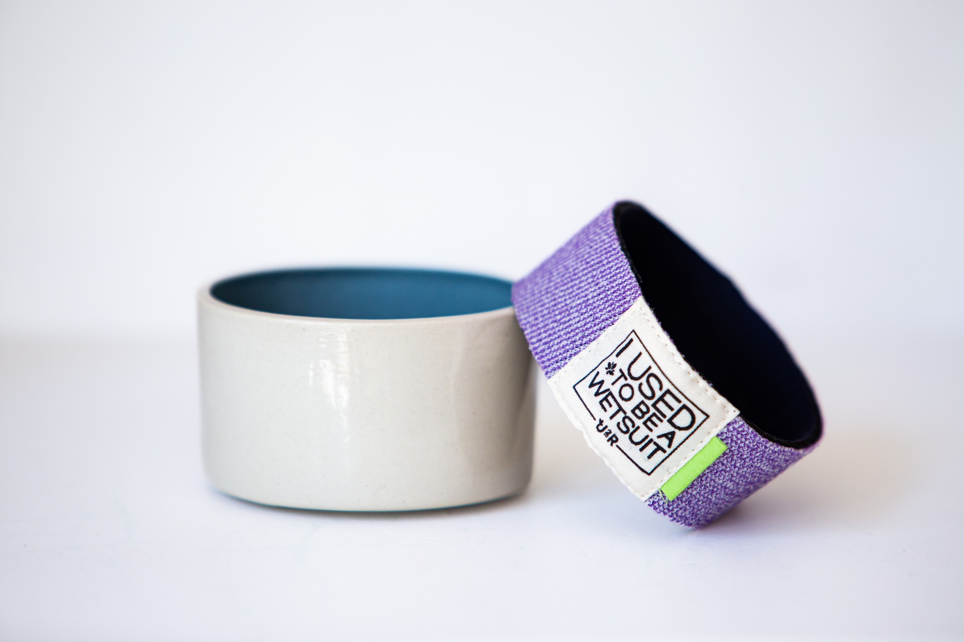 Sleeves no waste Dois anéis, um tecido lilás com etiqueta e outro cerâmico cinza com interior azul
