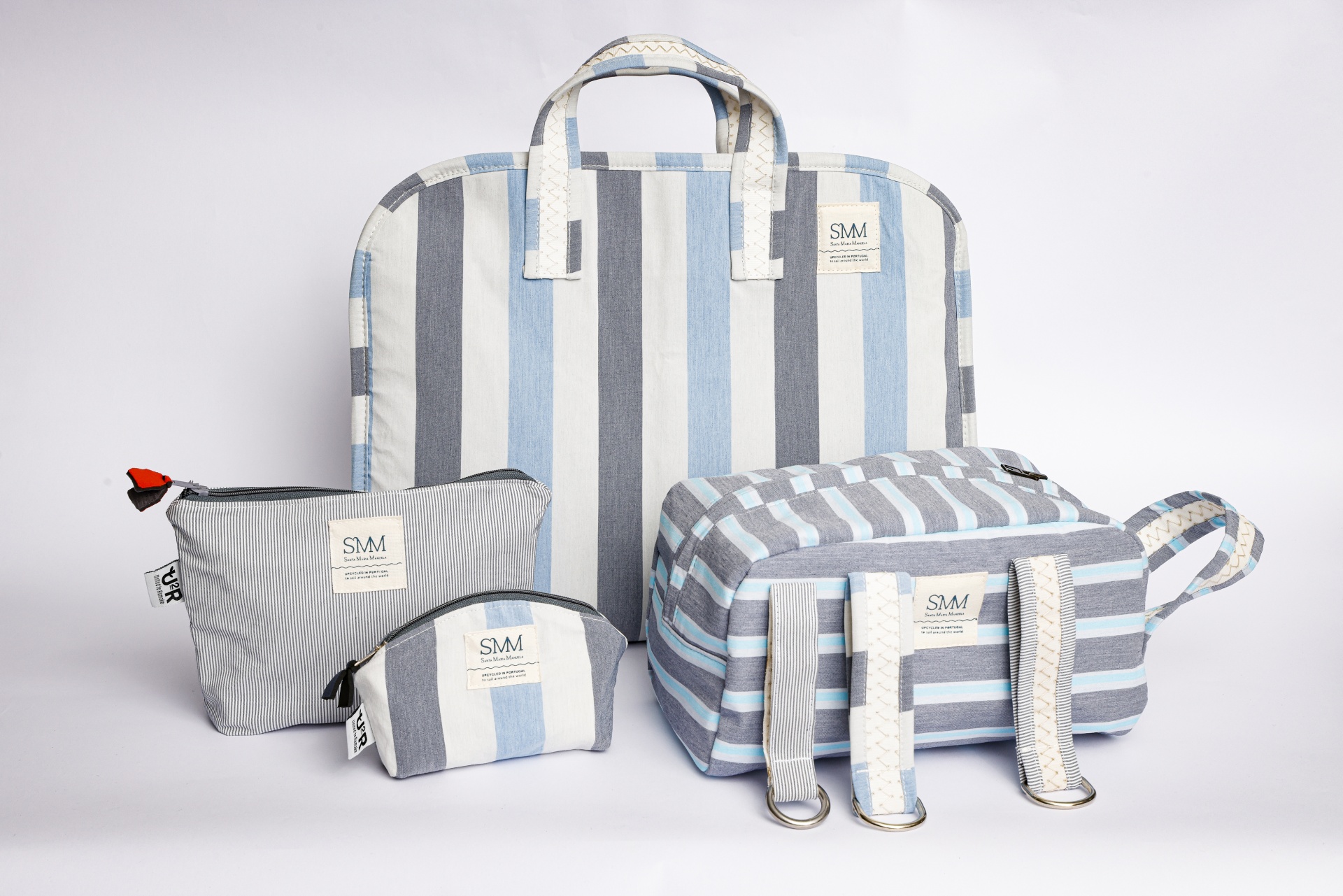 conjunto de bolsas e necessaires em tecido riscado cinza, azul e branco com etiquetas SMI premium