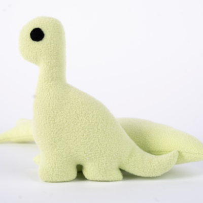 Pelúcia de dinossauro amarela com textura felpuda