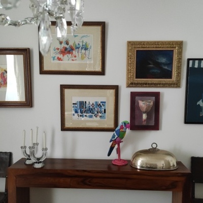 Mesa de madeira escura com decoração e quadros na parede